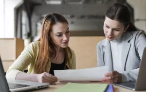 deux jeune femme affaires regarder papier dans bureau