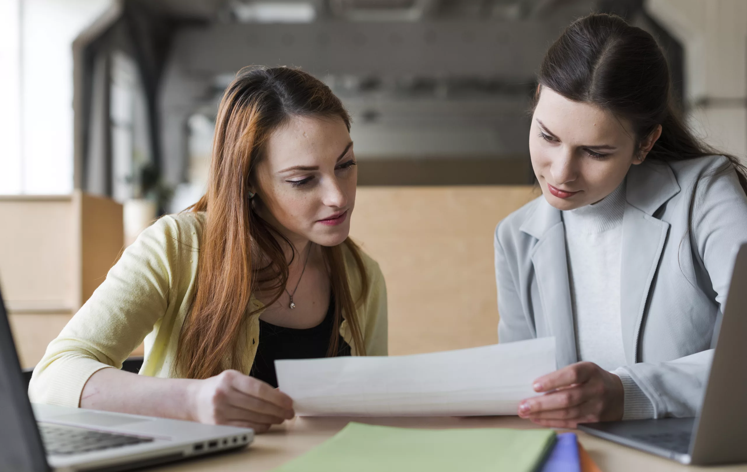 deux jeune femme affaires regarder papier dans bureau scaled
